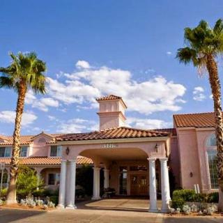 A sunny day at a hotel with palm trees and clear blue skies.