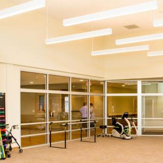 A modern office space featuring glass walls and contemporary lighting.