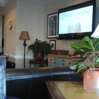 A cozy living room scene featuring a television, a lamp, and indoor plants.