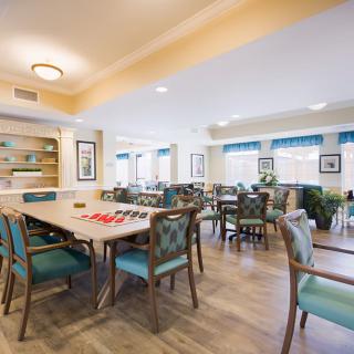 A spacious and well-lit dining area with multiple tables and chairs, suitable for social gatherings.