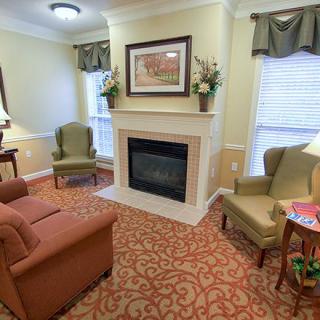 A cozy, traditionally styled living room with a fireplace and comfortable armchairs.