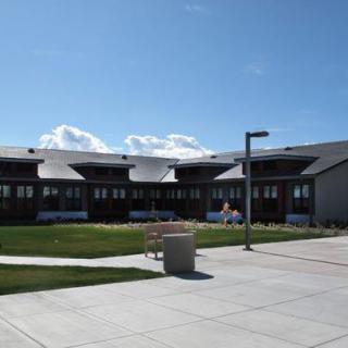 A sunny day at a school campus with a modern building and clear blue skies.