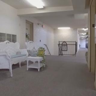 A white hallway with seating and a small table.