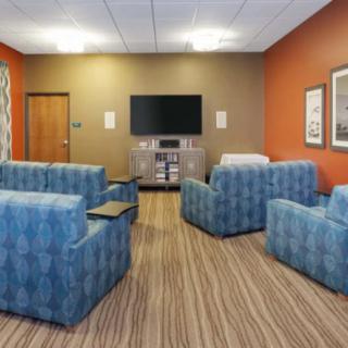 A cozy meeting room with blue couches and a television.