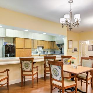 A cozy dining area featuring wooden furniture and a view into the kitchen.