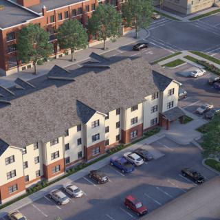 Aerial view of a residential building with a parking lot and surrounding streets.