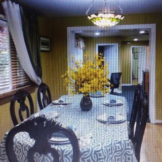 A cozy dining room with a patterned tablecloth, floral centerpiece, and decorative lighting.