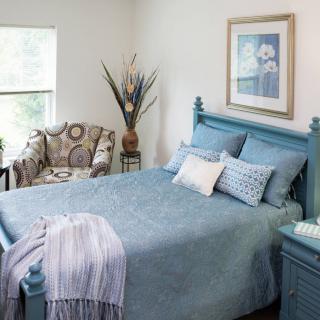 A cozy bedroom with blue bedding and elegant decor.