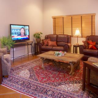 A cozy living room with sofas, a TV, and a patterned rug.