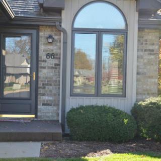 A well-maintained residential exterior featuring a decorative window and lush landscaping.