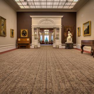 An elegant art gallery interior showcasing paintings and sculptures.