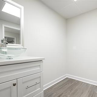 A minimalist bathroom with modern fixtures and light-colored flooring.