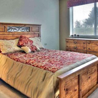 A cozy bedroom featuring a wooden bed and dresser, with natural light streaming through the window.