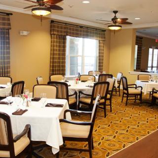 A well-arranged dining room with neatly set tables and comfortable chairs.