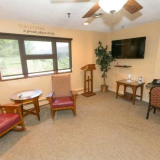 A cozy room with seating, a TV, and a large window.