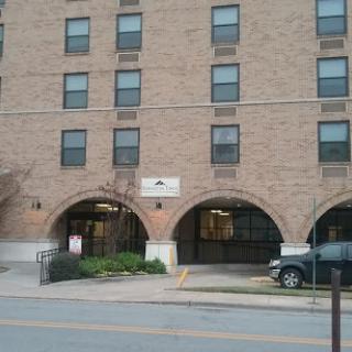 A brick building featuring multiple windows and an arched entrance.