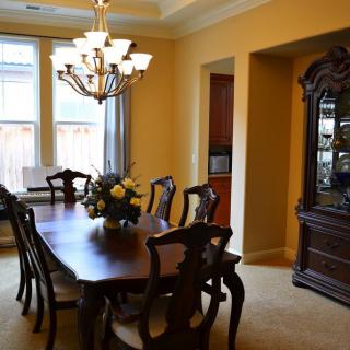 A formal dining room with elegant wooden furniture and a decorative chandelier.