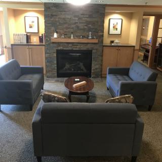 A cozy living room setup with sofas arranged around a fireplace and a central coffee table.