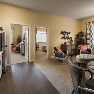 A modern apartment interior with an open layout featuring a living room and dining area.