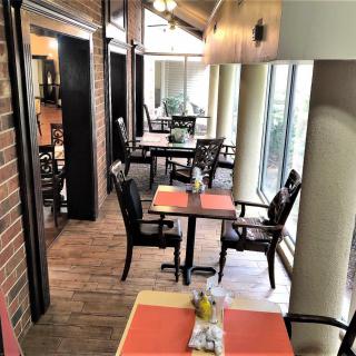 A cozy indoor dining area with natural light streaming through large windows.