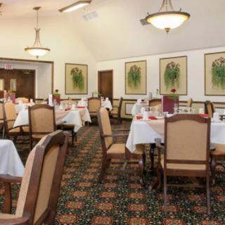 An elegant dining area with neatly arranged tables and chairs, featuring tasteful decor and lighting.
