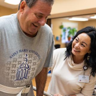 A healthcare professional supports a patient during rehabilitation, fostering a positive and encouraging environment.