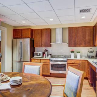 A modern kitchen with wooden cabinets and a dining table.