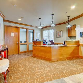 A welcoming reception area with a wooden desk and stylish lighting.