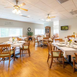 A well-lit dining area with neatly arranged tables and chairs.