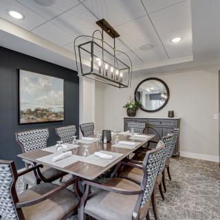 A modern dining room with a stylish chandelier and elegant table setting.