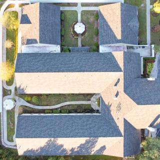 Aerial view of a building with intricate roof design and surrounding pathways.