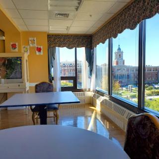 A spacious room with large windows showcasing a vibrant city view.