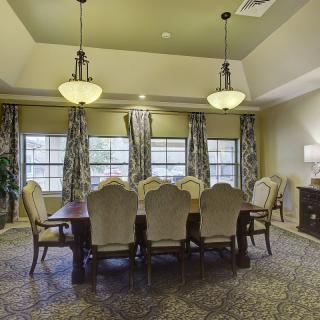Spacious dining room with an elegant table setting and decorative lighting.
