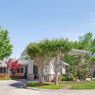 A sunny day at a residential building surrounded by trees and greenery.