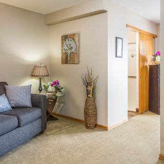 A cozy living room with a sofa, lamp, and decorative elements.