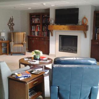 A cozy living room with bookshelves, a fireplace, and comfortable seating.