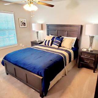 A modern bedroom with blue bedding and stylish decor.