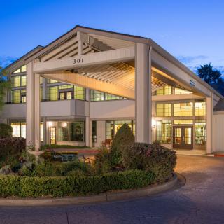 A well-lit hotel entrance with modern architecture during the evening.