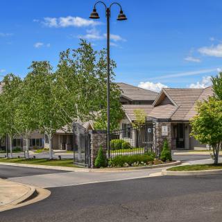 A residential building surrounded by trees on a sunny day.