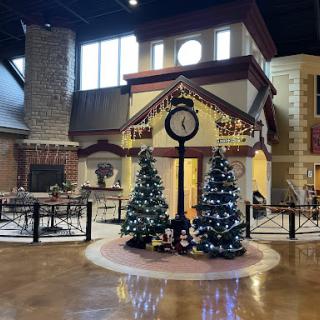 A beautifully decorated lobby featuring a large clock and festive Christmas trees.
