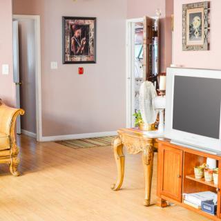 A cozy living room with a television, decorated with artwork and comfortable furniture.