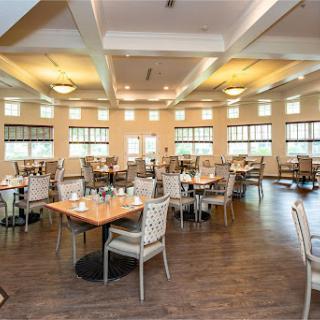 A spacious and inviting dining area, featuring modern tables and chairs with ample natural light.