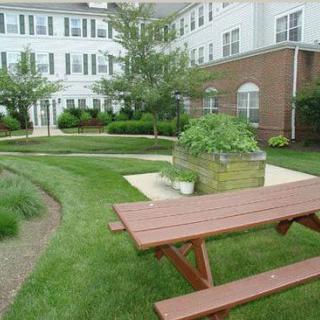 A well-maintained garden area with a picnic bench outside a residential building.
