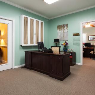 A well-organized office space with a wooden desk, computer, and comfortable seating.