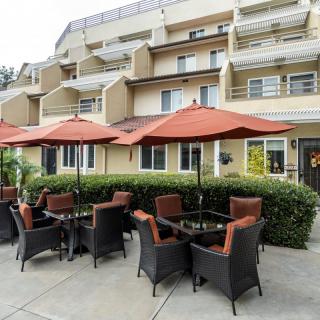 Outdoor patio area with comfortable seating and umbrellas at a modern building.