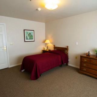 A cozy bedroom with a single bed and warm lighting.
