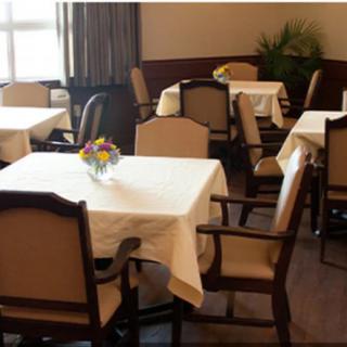 An elegantly set dining room with tables and chairs, ready for guests.