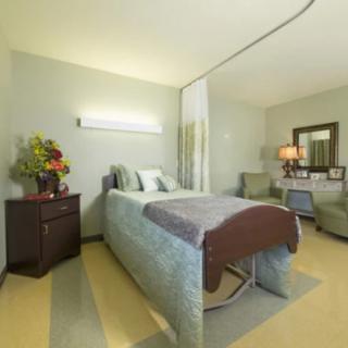 A well-appointed hospital room with a bed and comfortable furnishings.