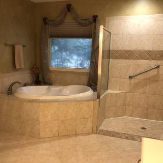 Spacious bathroom with a bathtub and walk-in shower.