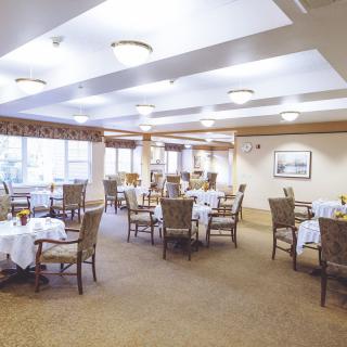 A spacious and well-lit dining area with neatly arranged tables and chairs.